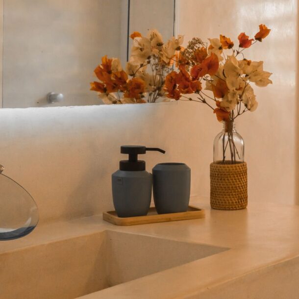 Stylish and minimalist bathroom counter setup with elegant floral decor and modern faucet design.
