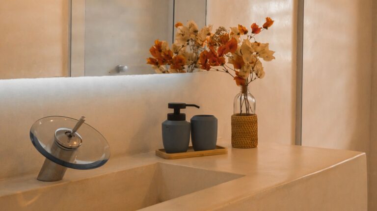 Stylish and minimalist bathroom counter setup with elegant floral decor and modern faucet design.