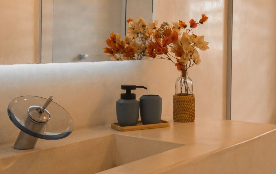 Stylish and minimalist bathroom counter setup with elegant floral decor and modern faucet design.