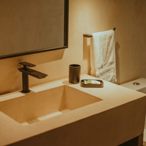 Elegant minimalist bathroom with contemporary fixtures, highlighting a sleek sink and faucet.