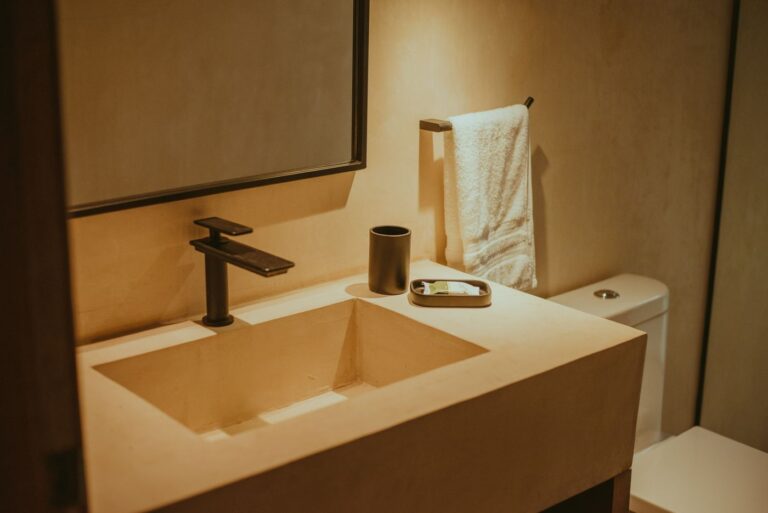Elegant minimalist bathroom with contemporary fixtures, highlighting a sleek sink and faucet.