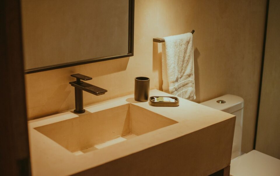 Elegant minimalist bathroom with contemporary fixtures, highlighting a sleek sink and faucet.