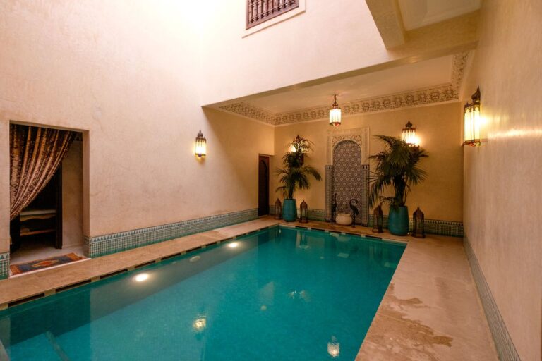 Elegant indoor pool in a Marrakesh riad, showcasing traditional Moroccan architecture and decor.